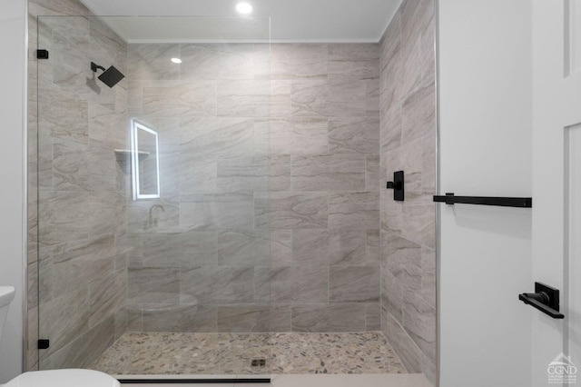 bathroom with tiled shower and toilet