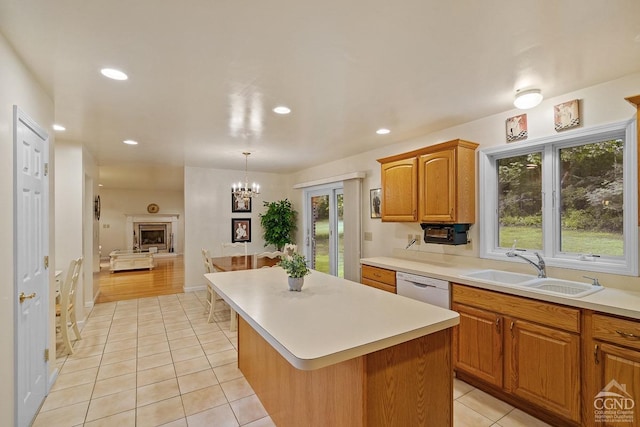 kitchen featuring dishwasher, sink, a notable chandelier, pendant lighting, and a kitchen island