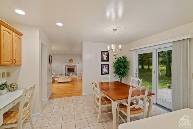 dining room with light hardwood / wood-style floors and a notable chandelier