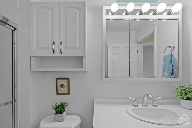 bathroom with vanity, an enclosed shower, and toilet