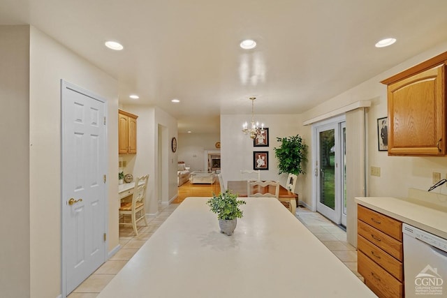 kitchen featuring light tile patterned floors, white dishwasher, hanging light fixtures, and a notable chandelier