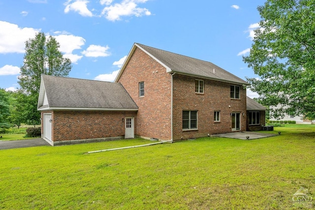 back of property featuring a lawn, a patio area, and a garage