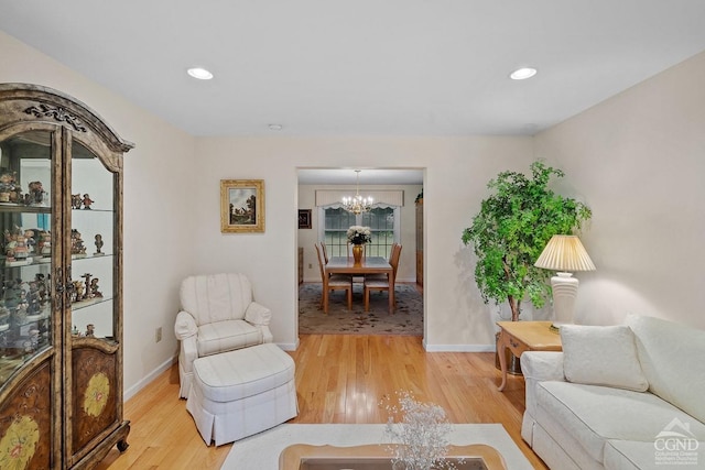 living room with hardwood / wood-style floors and an inviting chandelier