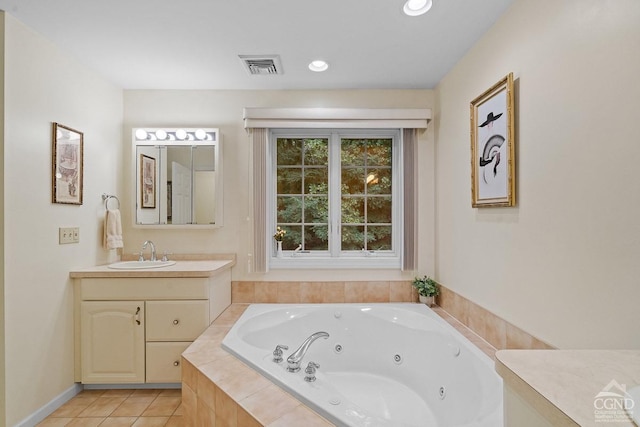 bathroom featuring tile patterned flooring, vanity, and tiled bath