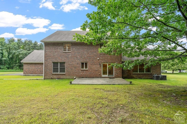 rear view of house featuring a lawn, central AC unit, and a patio area