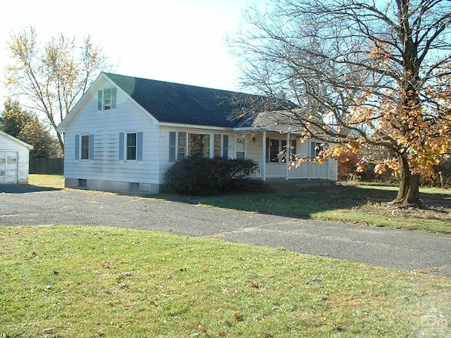 view of front facade with a front yard and an outbuilding