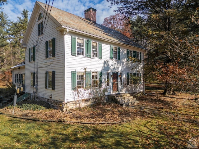 colonial-style house featuring a front yard