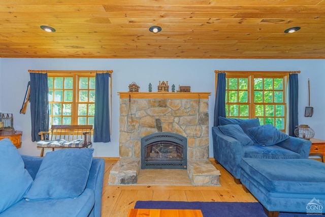 living room with a fireplace, light wood-type flooring, wooden ceiling, and a healthy amount of sunlight