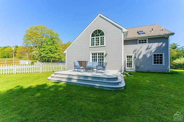 rear view of house featuring a lawn, a wooden deck, and outdoor lounge area