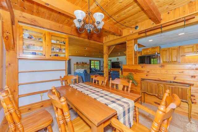 dining space with beamed ceiling, light hardwood / wood-style flooring, an inviting chandelier, and wooden ceiling