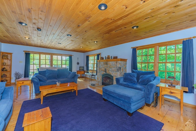 living room with a wood stove, light hardwood / wood-style flooring, wooden ceiling, and lofted ceiling