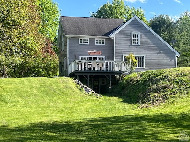 back of property with a lawn and a deck