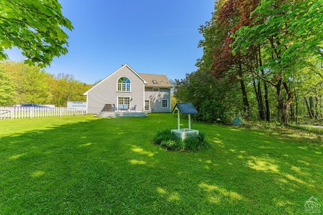 back of property with a deck and a lawn