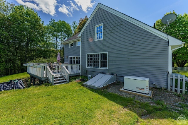 back of property with a yard and a wooden deck