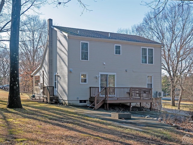 back of property featuring a lawn and a deck