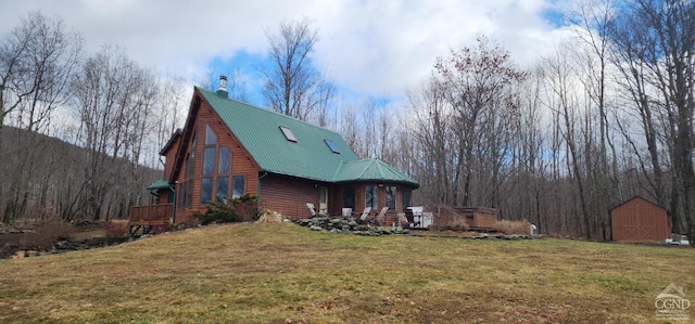 view of home's exterior with a yard and a storage unit