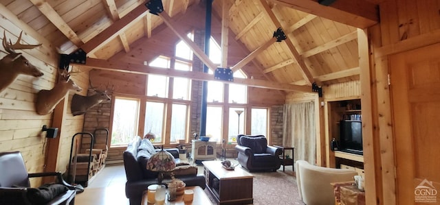 living room featuring wood walls, a healthy amount of sunlight, beam ceiling, and high vaulted ceiling