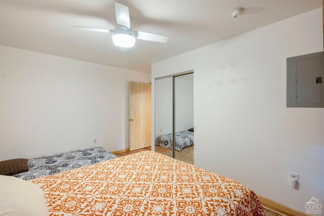 bedroom with ceiling fan, electric panel, and a closet