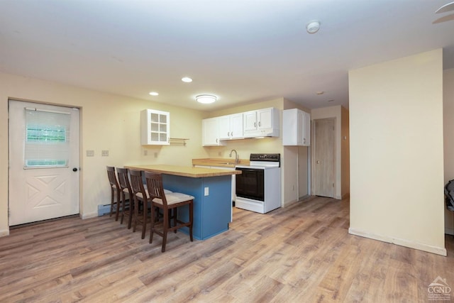 kitchen featuring kitchen peninsula, a breakfast bar, white cabinets, white electric range, and light hardwood / wood-style floors