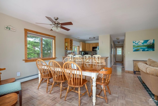 dining room featuring ceiling fan, baseboard heating, and light parquet flooring