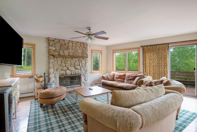 living room featuring a fireplace, light parquet flooring, ceiling fan, and a baseboard heating unit