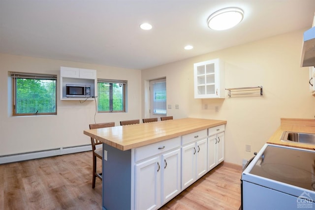 kitchen with white cabinetry, a kitchen bar, and butcher block counters