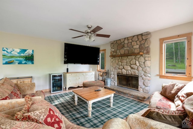 living room with ceiling fan, a fireplace, and wine cooler