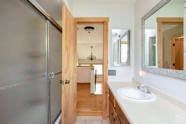 bathroom with a chandelier, vanity, and wood-type flooring