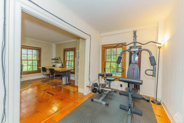 exercise area featuring light tile patterned flooring and ornamental molding