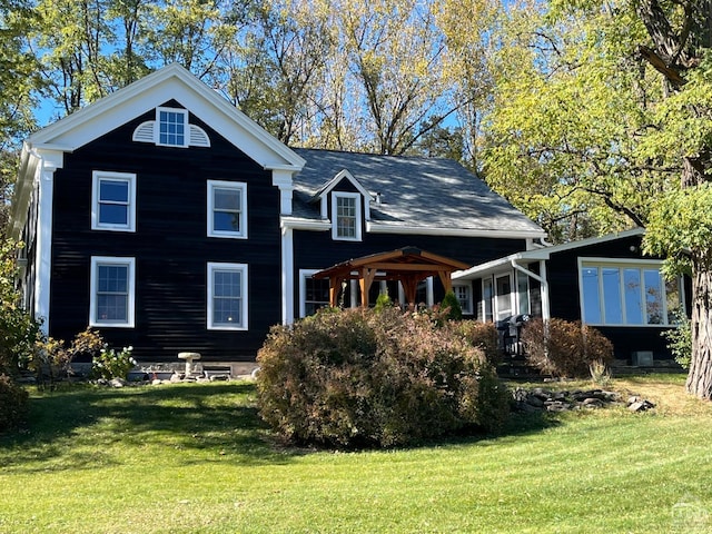 rear view of property featuring a yard