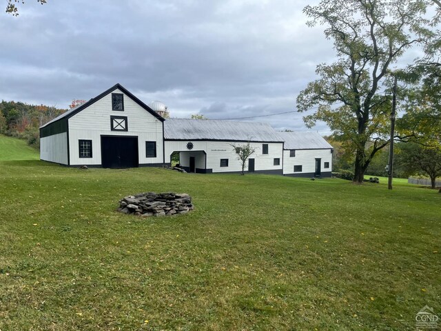 back of property with a yard and an outbuilding