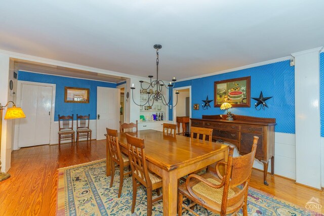 dining room featuring ornamental molding, a notable chandelier, and hardwood / wood-style flooring