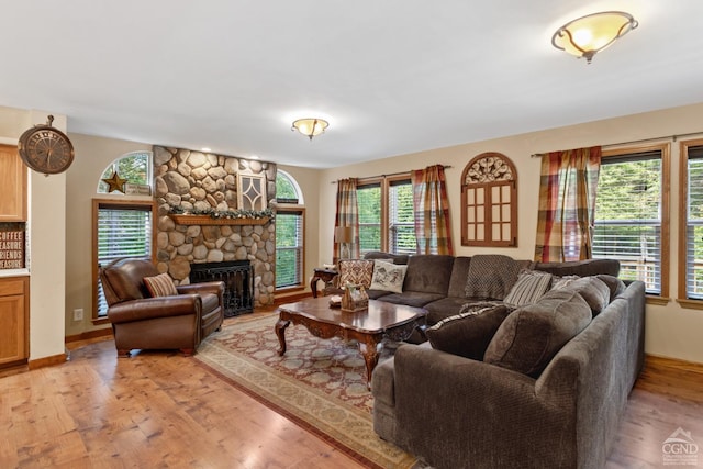 living room featuring light hardwood / wood-style floors and a stone fireplace