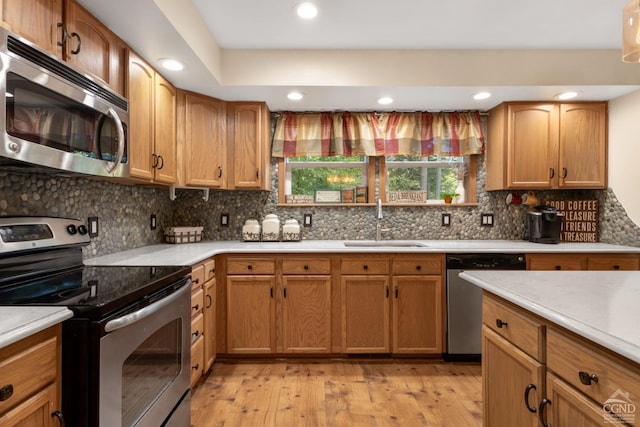 kitchen with backsplash, stainless steel appliances, light hardwood / wood-style flooring, and sink