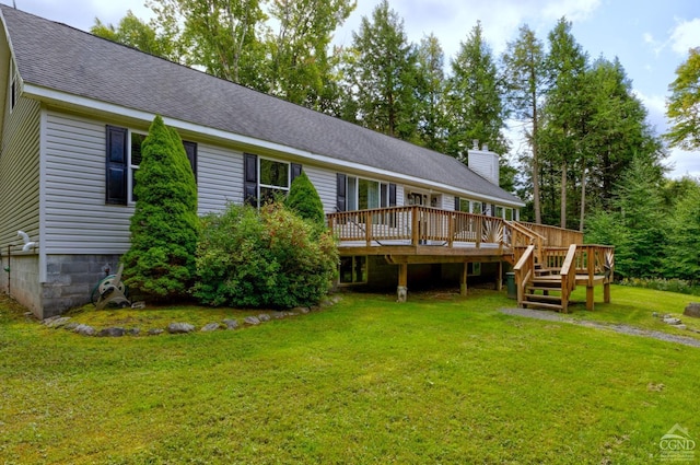 rear view of property featuring a yard and a deck