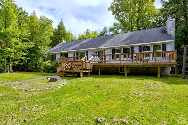 rear view of house with a deck and a yard