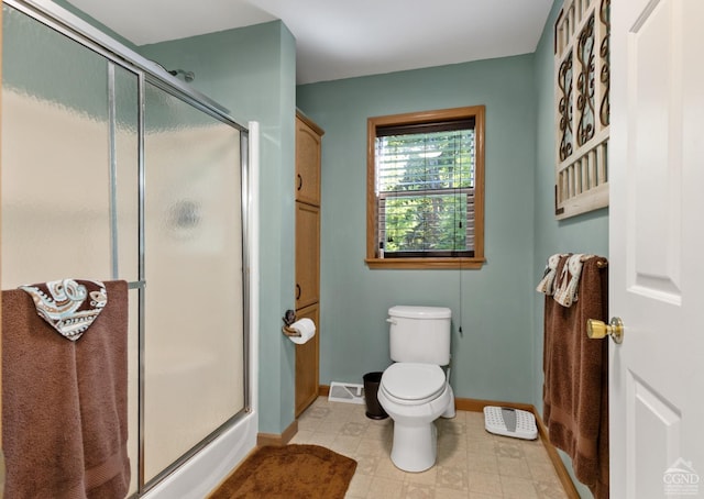 bathroom with toilet and a shower with shower door