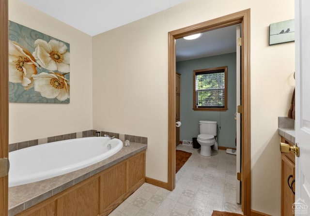 bathroom with a bathing tub, vanity, and toilet