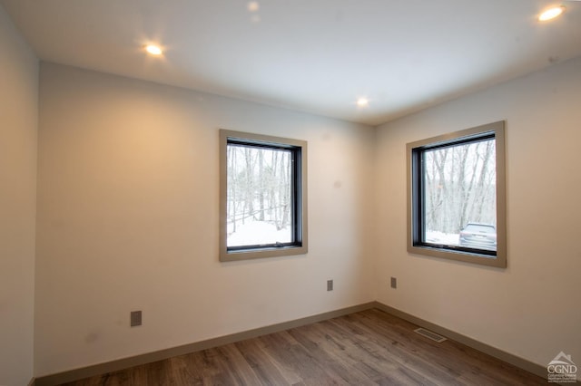 spare room with visible vents, recessed lighting, baseboards, and wood finished floors