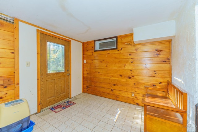 entryway with light tile patterned floors and wood walls