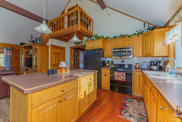 kitchen featuring hardwood / wood-style floors, a center island, black appliances, sink, and decorative light fixtures