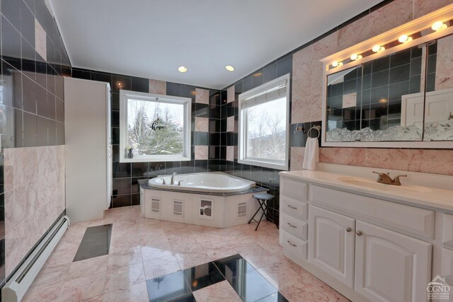 bathroom with vanity, a bath, baseboard heating, and tile walls