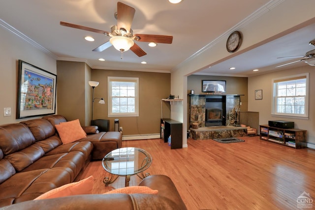 living room featuring ceiling fan, ornamental molding, baseboard heating, and light hardwood / wood-style flooring