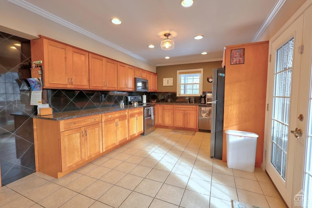 kitchen with decorative backsplash, dark stone counters, ornamental molding, stainless steel appliances, and light tile patterned floors