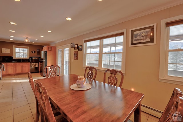 dining area featuring baseboard heating, crown molding, and light tile patterned flooring