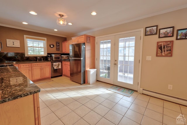 kitchen featuring appliances with stainless steel finishes, plenty of natural light, french doors, and a baseboard heating unit