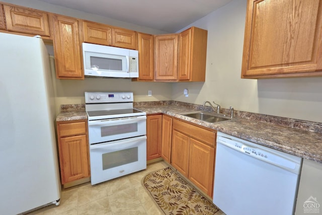 kitchen featuring light tile patterned flooring, dark stone countertops, white appliances, and sink