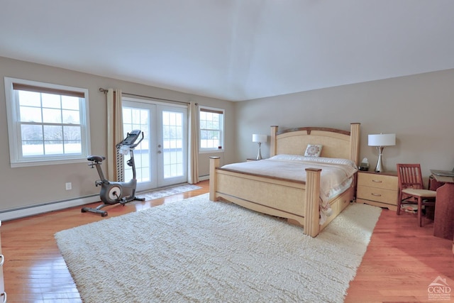 bedroom featuring access to exterior, french doors, hardwood / wood-style floors, and a baseboard heating unit