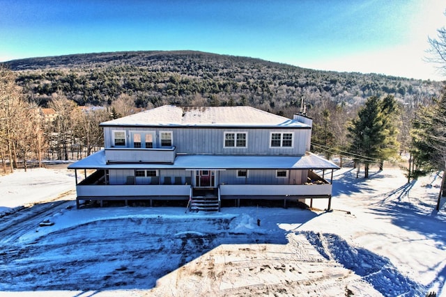 rear view of property featuring a forest view