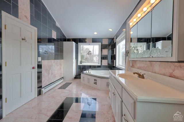 bathroom featuring a washtub, tile walls, vanity, and a baseboard radiator